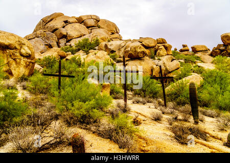 Drei hölzerne Kreuze auf einem Hügel mit großen Felsbrocken im Hintergrund wie in Arizona, USA gesehen Stockfoto