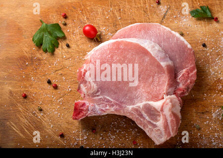 Frisches Schweinekoteletts rohes auf ein Schneidebrett mit Kräutern Stockfoto