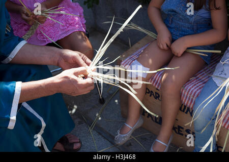 Badajoz, Spanien - 24. September 2016: Handwerker, Kindern beizubringen, um Pflanzenfasern Zopf Stockfoto