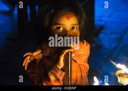 Nepali Kind mit Stirn Bindi an Kamera suchen bei Kerzenschein in der Nacht. Kathmandu. Nepal Stockfoto