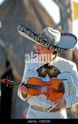 Mariachi Violine Spieler führt am Sunny Beach während Hochzeit Sombrero Hut & weißen Anzug mit Gold Eimer in Mexiko Stockfoto