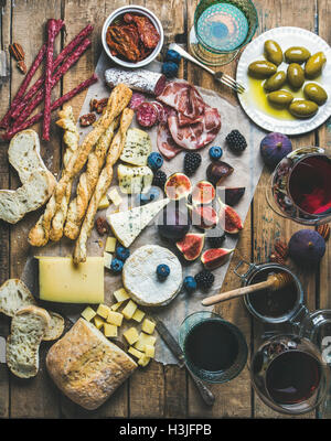 Wein und snack-Set mit verschiedenen Weinen in Gläser, Fleisch-Vielfalt, Brot, grüne Oliven, getrockneten Tomaten, Feigen, Nüssen und Beeren Stockfoto
