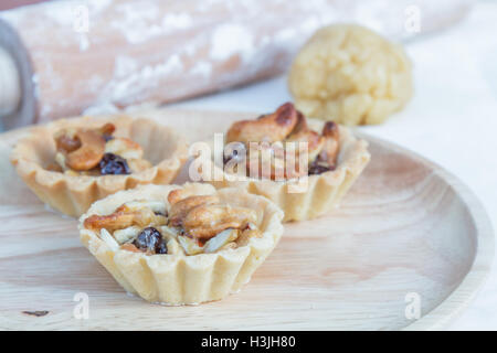 Herb Cashewkerne und Rosinen auf Holz Platte aus Holz Nudelholz Hintergrund. Stockfoto