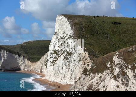 Weiße Kreidefelsen, entlang der Klippe und der Strand mit Menschen zu Fuß entlang der Schindel sowie fossile Jäger suchen. Stockfoto