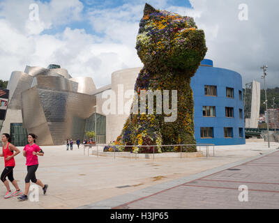 Ausführen von Jeff Koons Puppy Blumenskulptur außerhalb Guggenheim Museum Bilbao Stockfoto