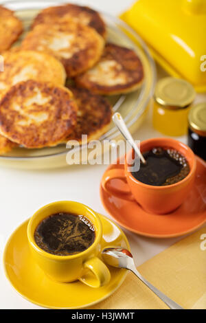 Frühstück. Quark Pfannkuchen und zwei Tassen Kaffee. Selektiven Fokus. Stockfoto