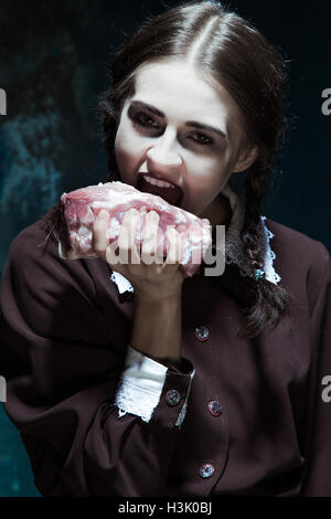 Blutige Halloween-Thema: Verrücktes Mädchen mit rohem Fleisch Stockfoto