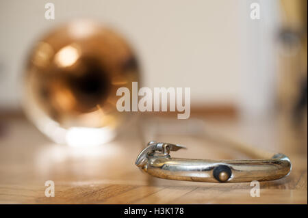 Posaune Bell auf braune Holzparkett, Wasser wichtige Ventil Detail selektiven Fokus Stockfoto