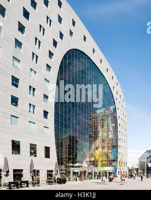 Seitenansicht von geschwungenen Gebäude und Passanten auf dem öffentlichen Platz. Markthalle Rotterdam, Rotterdam, Niederlande. Architekt: MVRDV, 2014. Stockfoto