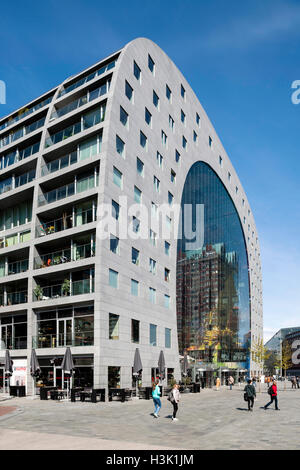 Seitenansicht des geschwungenen Gebäude mit Kontext und Passanten auf dem öffentlichen Platz. Markthalle Rotterdam, Rotterdam, Niederlande. Architekt: MVRDV, 2014. Stockfoto