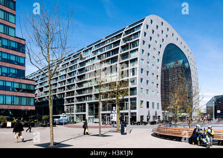 Seitenansicht des geschwungenen Gebäude mit Kontext und Passanten auf dem öffentlichen Platz. Markthalle Rotterdam, Rotterdam, Niederlande. Architekt: MVRDV, 2014. Stockfoto