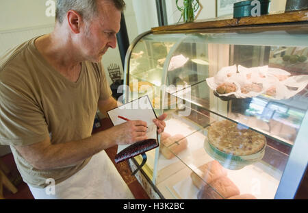 Café-Besitzer überprüfen Inventar von Süßwaren Stockfoto
