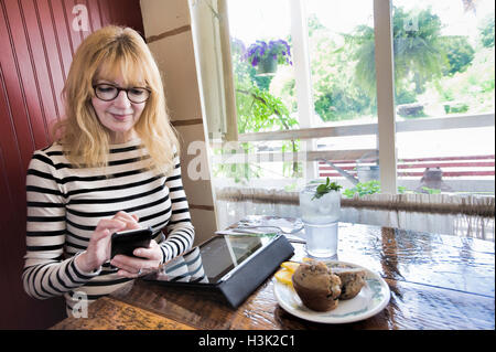 Frau mit Handy, arbeiten mit digitalen Tablet im café Stockfoto