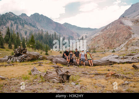 Gruppe von Freunden sitzen auf Log, Mineral King, Sequoia Nationalpark, Kalifornien, USA Stockfoto