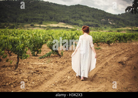 Junge Frau, die zu Fuß durch Weinberge, Rückansicht, Boutenac, Frankreich Stockfoto