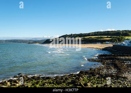 Benllech, Isle of Anglesey, Wales, UK, Großbritannien. 9. Oktober 2016. Blick entlang des Strandes mit einer eingehenden Flut und Menschen Flanieren auf dem Sand auf einem schönen sonnigen Oktobertag. Stockfoto