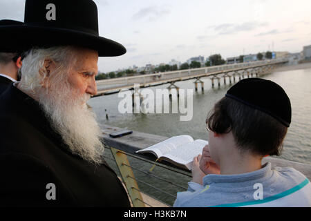 Tel Aviv, Israel. 9. Oktober 2016. Ultra-orthodoxe Juden beten, wie sie in Tashlich am Ufer des Mittelmeers in Tel Aviv, Israel, 9. Oktober 2016 teilnehmen. Tashlich ist ein Ritual, während die Gläubigen ihre Sünden in das Wasser und die Fische gegossen, und es erfolgt vor der Versöhnungstag oder Yom Kippur, der wichtigste Tag des jüdischen Kalenders. Bildnachweis: Gil Cohen Magen/Xinhua/Alamy Live-Nachrichten Stockfoto