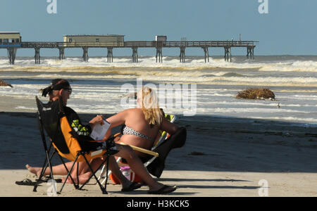 Daytona Beach, Florida, USA. 9. Oktober 2016. Ein paar entspannt am Strand in der Nähe von SunGlow Fishing Pier, am 7. Oktober 2016 stark beschädigt wurde als Hurrikan Matthew Daytona Beach, Florida zugeschlagen. Raue Brandung vor dem Sturm weggespült 60 Fuß vom Ende des Piers. Matthew ist eines der stärksten Hurrikane zu je Teig die US-Küste. © Paul Hennessy/Alamy Live News Bildnachweis: Paul Hennessy/Alamy Live-Nachrichten Stockfoto