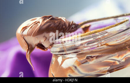 Nutella in Löffel. Ein Glas mit Haselnuss Schokolade verteilt. Stockfoto