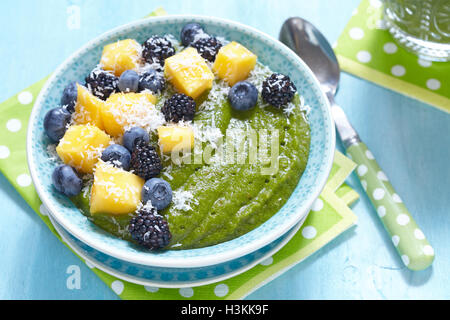 Frühstück im grünen Smoothie Schüssel mit Früchten garniert Stockfoto