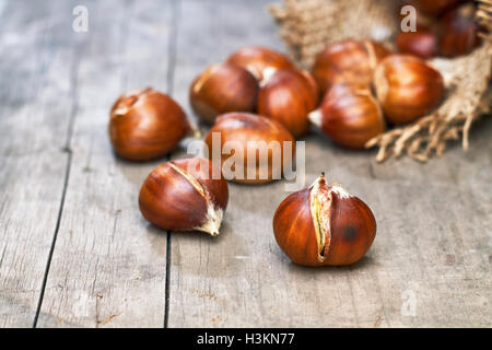 Geröstete Kastanien auf grauen rustikalen Holztisch. Textfreiraum Stockfoto