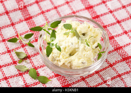 Nahaufnahme von hausgemachten Schmelzkäse mit Kräutern in Glasschale Stockfoto