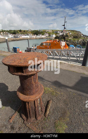 Portpatrick, Schottland. Eine rostige Poller im Hafen von Portpatrick, mit der RNLB John Buchanan Barr im Hintergrund. Stockfoto