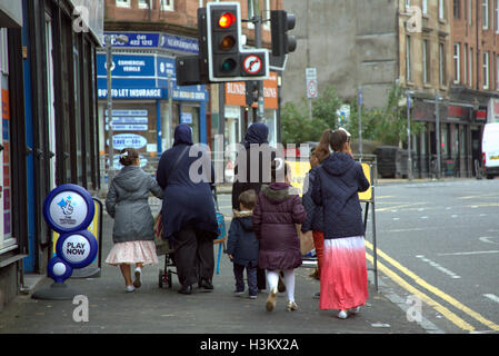 Asiatische Familie Flüchtling gekleidet Hijab Schal auf Straße in den UK alltägliche Szene Lotterie Zeichen Stockfoto