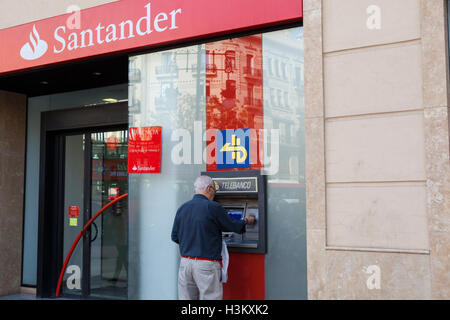 Ein Mann nutzt eine Santander ATM Geld abheben Stockfoto