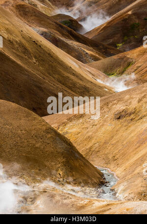 Fluss mit roten und braunen Hügeln und Dampf in Kerlingarfjoll auf Island. Stockfoto