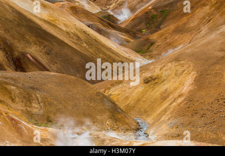 Fluss mit roten und braunen Hügeln und Dampf in Kerlingarfjoll auf Island. Stockfoto