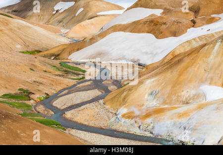 Rote und braune Hügel mit Schnee und Dampf in Kerlingarfjoll auf Island. Stockfoto