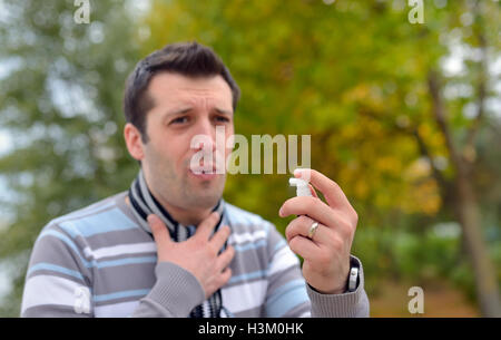 Junger Mann mit Hals-Spray in der kalten Jahreszeit Stockfoto