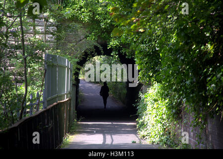 Silhouetten von Menschen in der Stadt vor dem Hintergrund des Eingangs im Brücke-Tunnel im Westend von Glasgow im park Stockfoto