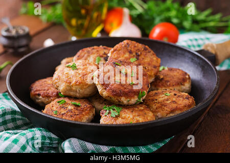 Saftige leckere Fleisch Schnitzel in die Pfanne auf einem Holztisch. Stockfoto