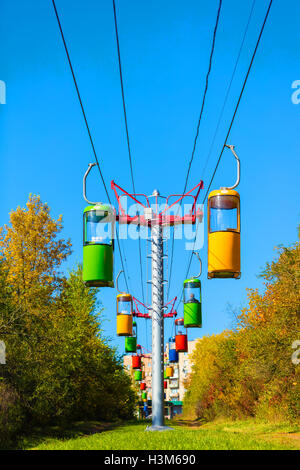 Seilbahn mit bunten Hütten in den herbstlichen Wald Stockfoto