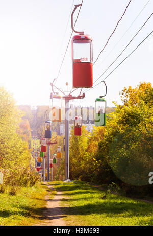 Seilbahn mit bunten Hütten in den herbstlichen Wald Stockfoto