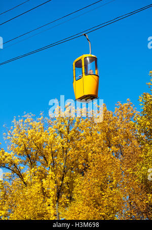 Seilbahn mit bunten Hütten in den herbstlichen Wald Stockfoto