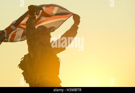 Britischer Soldat mit UK Flagge in seinen Händen. Militärisches Konzept. Stockfoto