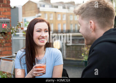 Junges Paar im Chat auf Terrasse Stockfoto