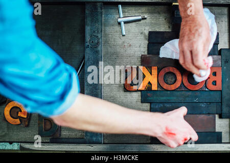 Detail der Hände mit Letterpress Maschine im Buch-Kunst-Workshop, Draufsicht Stockfoto