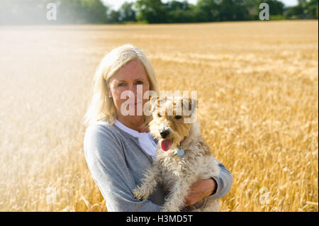 Reife Frau im Feld stehen, mit Hund Stockfoto