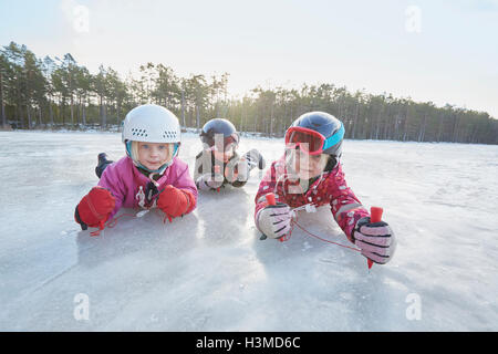 Porträt von Mädchen und jungen kriechen auf zugefrorenen See, Hotels, Schweden Stockfoto