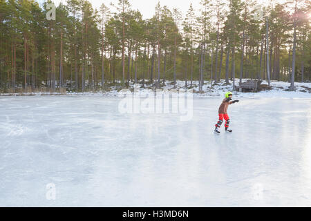 Junge Eislaufen auf dem zugefrorenen See, Hotels, Schweden Stockfoto