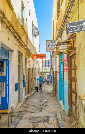 Der alte bunte Schilder der Geschäfte und Werkstätten schmücken die schmale Straße von Medina von Sfax. Stockfoto