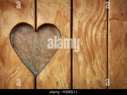 Eine Herzform, Symbol der Liebe und Romantik, Holz geschnitzt in Vintage old Grunge natürliche braune Holzbohlen Textur Zeitmessung geschnitten Stockfoto