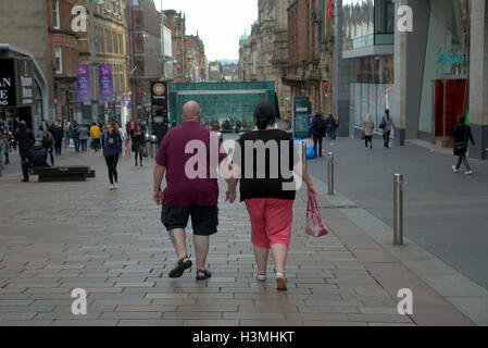 Glasgow Straßenszenen Übergewicht paar Hand in Hand an der Buchanan street Stockfoto