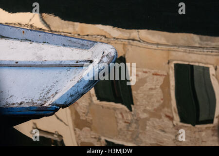 Der Bug eines Bootes in einem Kanal mit Reflexionen in Venedig Stockfoto