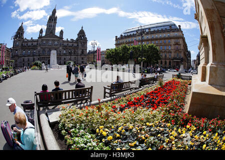 George Square und die Stadt Kammern mit der Kenotaph in Glasgow Stadtzentrum einheimische und Touristen entspannen und die Sonne genießen Stockfoto