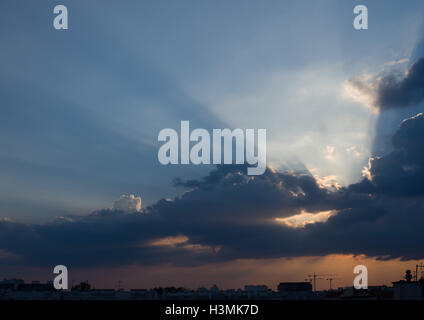 Bewölkten Sonnenuntergang mit crepuscular Rays über Dächer Stockfoto